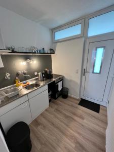una pequeña cocina con fregadero y puerta en KnocksCasa4You Apartment Nr 16 en Marburg an der Lahn