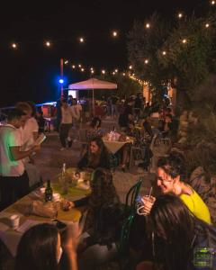 um grupo de pessoas sentadas às mesas à noite em Azienda Agricola Ausono em Piaggine