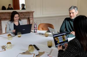 Un groupe de personnes assises autour d'une table avec des ordinateurs portables dans l'établissement Artyster Le Mans, au Mans