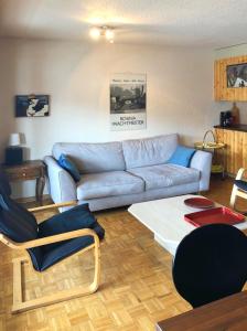 a living room with a blue couch and chairs at Appartement à 200m de la télé-cabine de Vercorin in Vercorin