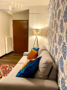 sala de estar con sofá y almohadas azules y naranjas en Residenza Bella, en Vicenza