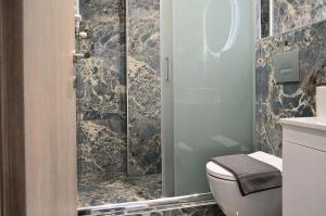 a bathroom with a toilet and a glass shower at Ippokratio Luxury Apartment in Thessaloniki +37 photos