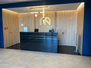 a lobby of a restaurant with a blue counter and a sign at Modern Vero Apartments Górskiego in Gdynia