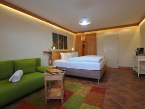 een slaapkamer met een bed en een groene bank bij Bauernstube Morgenitz in Morgenitz