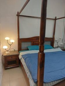 um quarto com uma cama de dossel com lençóis azuis em apartment in Ajman for 4 persons near the sea em Ajman