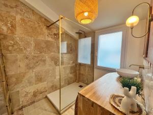 a bathroom with a glass shower and a sink at Le Petit Bohème - Cocon Rochelais in La Rochelle