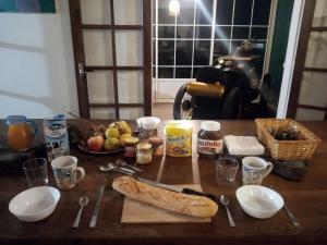Ti'Kratèr Chambres et tables d'hôtes في لو تامبون: طاولة مع رغيف خبز ومكونات أخرى