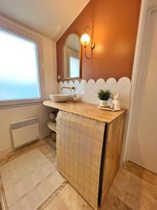 ein Bad mit einem Waschbecken und einem Spiegel in der Unterkunft Le Petit Bohème - Cocon Rochelais in La Rochelle