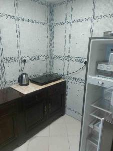 uma cozinha com um lavatório e um frigorífico em apartment in Ajman for 4 persons near the sea em Ajman