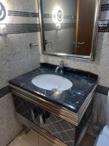 uma casa de banho com um lavatório e um espelho em apartment in Ajman for 4 persons near the sea em Ajman