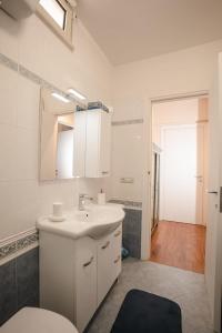 bagno bianco con lavandino e specchio di B&b Villa Maria Di Venere a Bari