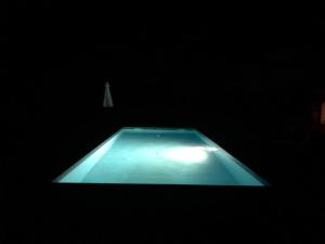 a dark room with a swimming pool in the dark at La Chartreuse et son Orangerie in Bergerac