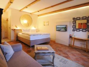 梅伦新Bauernstube Morgenitz的一间卧室，里面有一张床、一张沙发和一张桌子