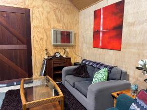 un soggiorno con divano e tavolo di Waiora la grange cottage a Otaki