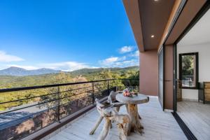 a balcony with a table and a view of the mountains at DOMAINE OLMETA in Porticcio