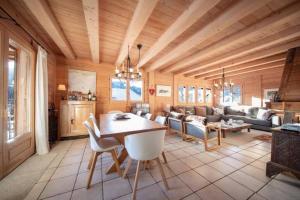 a living room with a wooden ceiling and a table and chairs at Chalet Renard in Morzine in Montriond