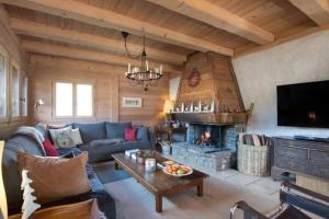 a living room with a couch and a fireplace at Chalet Renard in Morzine in Montriond