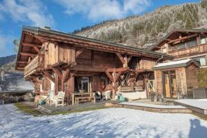 a log cabin in the mountains with a patio at Chalet Renard in Morzine in Montriond