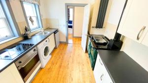 a kitchen with a sink and a washing machine at Pentland Farm Cottage Annex in Kirknewton