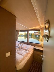 ein Bett auf der Rückseite eines Bootes mit Fenster in der Unterkunft schwimmendes Luxboot in Parey