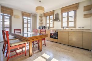 a kitchen with a wooden table and some chairs at Glamorous Flat with Jacuzzi near Hadrians Gate in Antalya