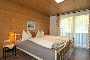1 dormitorio con 1 cama en una pared de madera en Haus Ronna, en Schruns