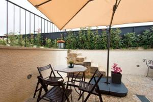 een patio met een tafel en stoelen en een parasol bij Urban Cabin in Vila Nova de Gaia