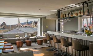 a restaurant with a bar with a view of the city at Select Hotel Moser Verdino Klagenfurt in Klagenfurt