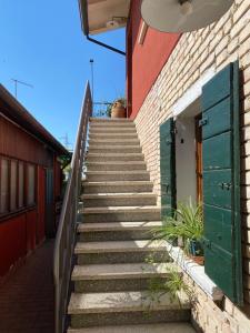 ミラーノにあるOsteria Locanda Dalla Linaの緑のドアのある建物へと続く階段