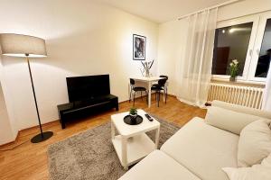 - un salon avec un canapé blanc et une table dans l'établissement Cozy Apartment in Wuppertal, à Wuppertal