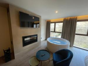 a large bathroom with a tub and a tv at Almazara Suites in Alcalá del Júcar