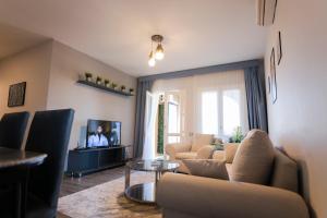 El Gouna Elite Villa's & Apartment's Private Residence with Sea & Garden View's - Hurghada في الغردقة: غرفة معيشة مع أريكة وتلفزيون