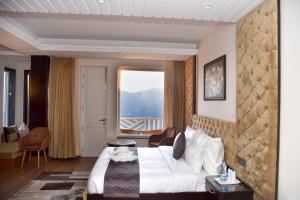 AnantVilas Shimla Hills في شيملا: غرفة فندقية بسرير ونافذة كبيرة