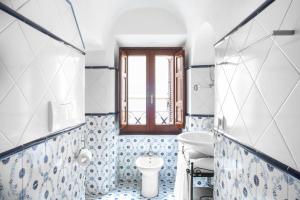 een badkamer met blauwe en witte betegelde muren en een raam bij Hotel Piazza Di Spagna in Rome