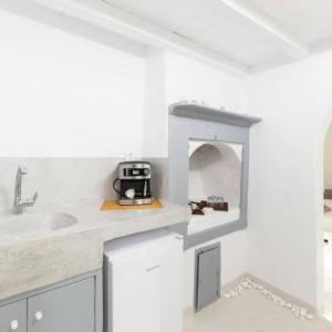 uma cozinha com um balcão com um lavatório e um micro-ondas em Melina's House Mykonos Town em Míconos