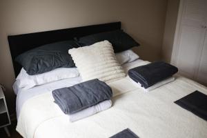 a bed with towels and pillows on top of it at Hullidays - Hymers Apartment in Hull