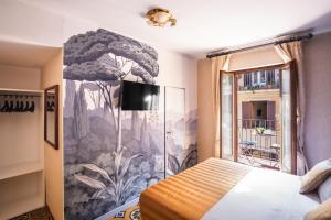 a bedroom with a tree mural on the wall at Hotel Piazza Di Spagna in Rome