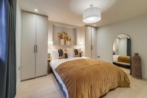 1 dormitorio con 1 cama grande y espejo en Argyle Apartments, Kings Cross, en Londres