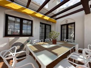 a dining room with a table and white chairs at Aldea Blanca Cozy Penthouse in Puerto Banús in Marbella
