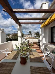 a balcony with a wooden pergola and a plant at Aldea Blanca Cozy Penthouse in Puerto Banús in Marbella