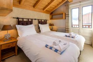 Dos camas en una habitación con toallas. en Chalet le Tremplin, en Chamonix-Mont-Blanc