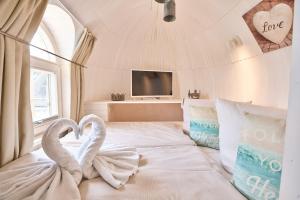 2 cigni seduti su un letto in una camera da letto di schwimmendes Iglu Romantik & Family a Parey