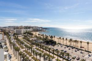 a view of a beach with palm trees and the ocean at Apartamento Rodas Arysal in Salou