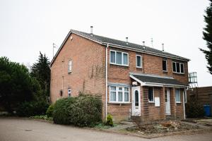 una casa de ladrillo rojo con techo negro en Hullidays - Hymers Apartment en Hull