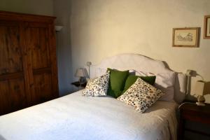 una camera da letto con un letto bianco e cuscini sopra di Piccozzo agritour a Casciana Terme