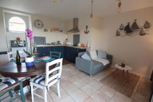 eine Küche und ein Wohnzimmer mit einem Tisch und einem Sofa in der Unterkunft Le Manoir de KEROFIL 