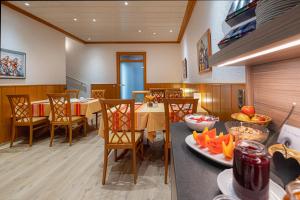 une salle à manger avec une table, des chaises et de la nourriture sur une table dans l'établissement Hotel Phönix, à Rastatt