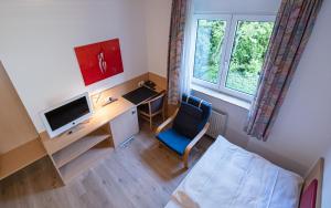 Habitación con escritorio, ordenador y ventana. en Hotel Phönix, en Rastatt