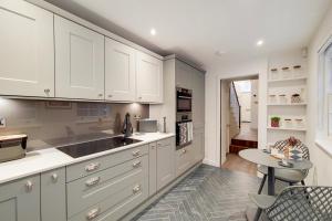 a kitchen with white cabinets and a table at Argyle Apartments, Kings Cross in London