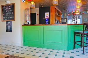 un bar verde en un restaurante con barra en OYO The White Horse, Ripon North Yorkshire, en Ripon